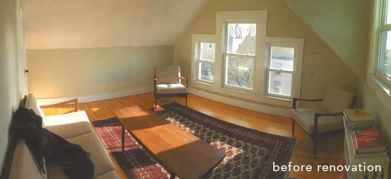 Minimalist attic room with wooden floors, chairs, and large windows