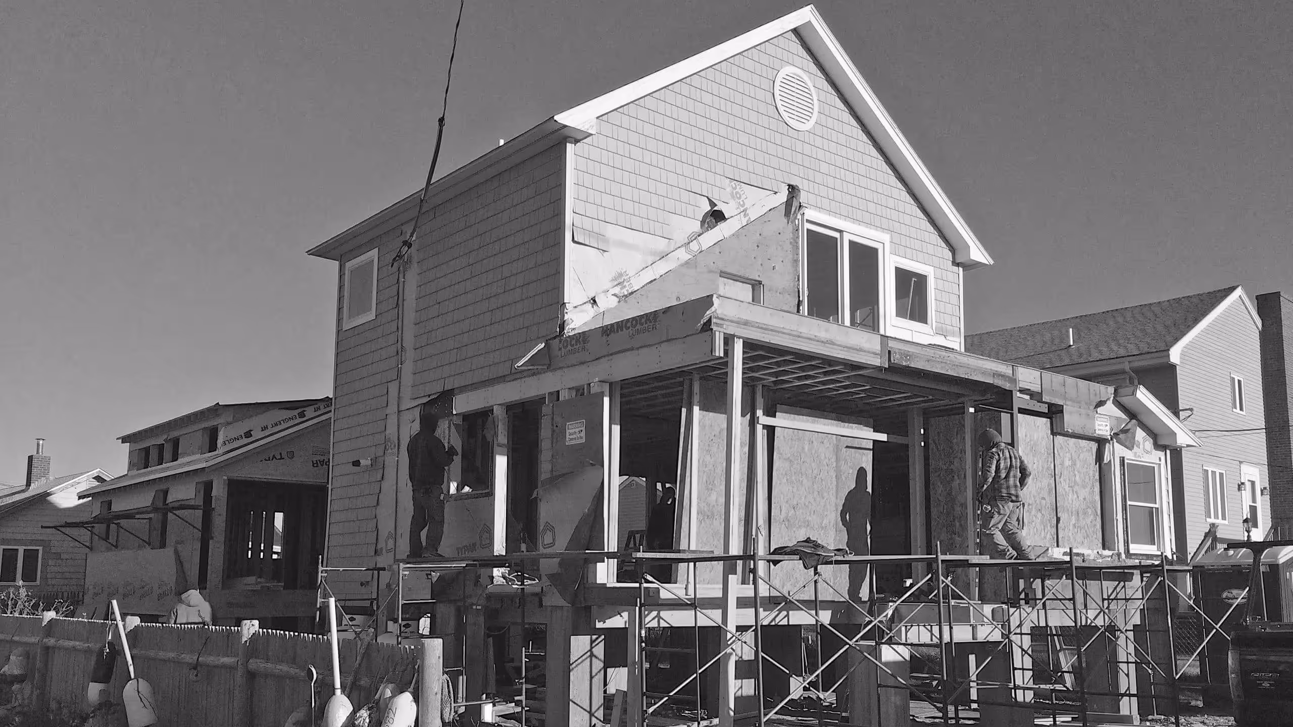 Black and white image of house under construction with scaffolding