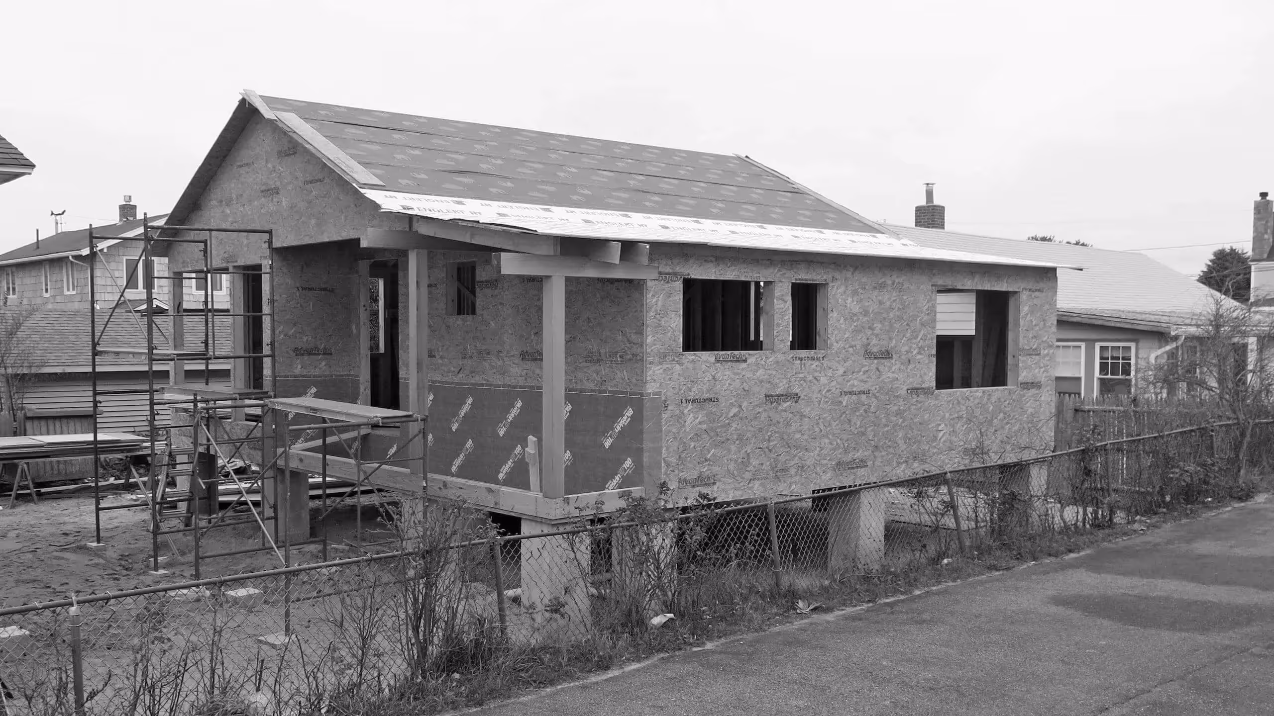 Black and white image of a house under construction with scaffolding