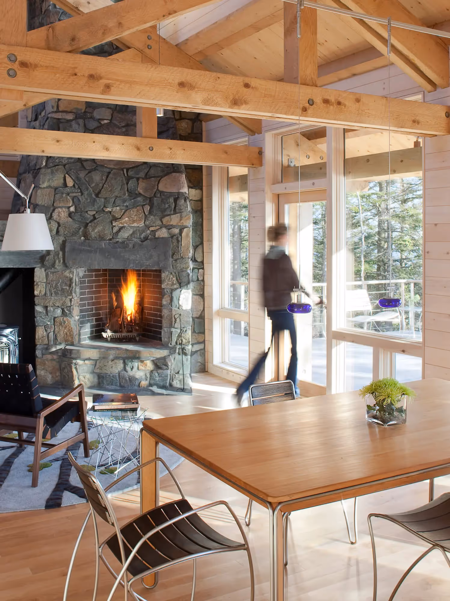 Cozy wooden cabin interior with stone fireplace and large windows