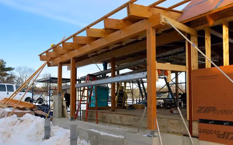 Wooden frame construction site with scaffolding and building materials
