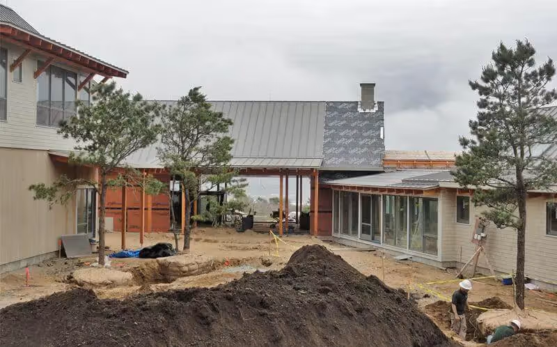 Modern house construction site with dirt piles and partially built structures