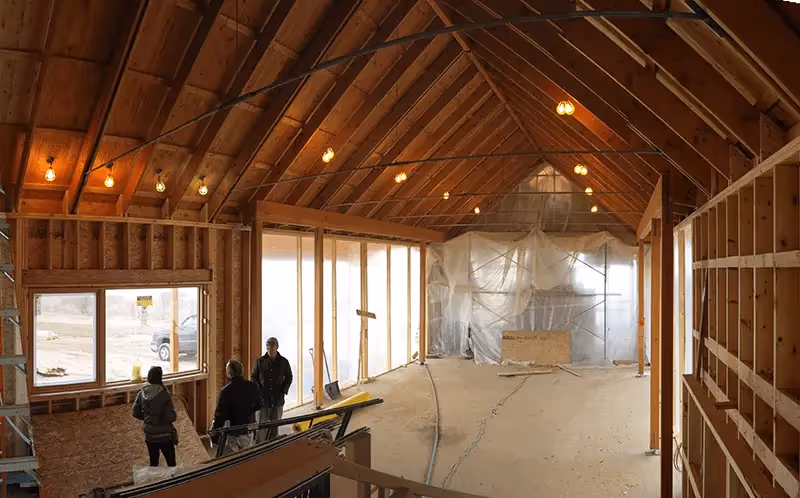 Wooden framed interior of building under construction with hanging lights