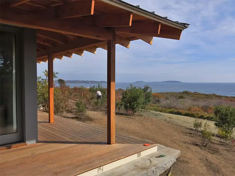 Wooden deck overlooking coastal landscape with ocean and distant islands