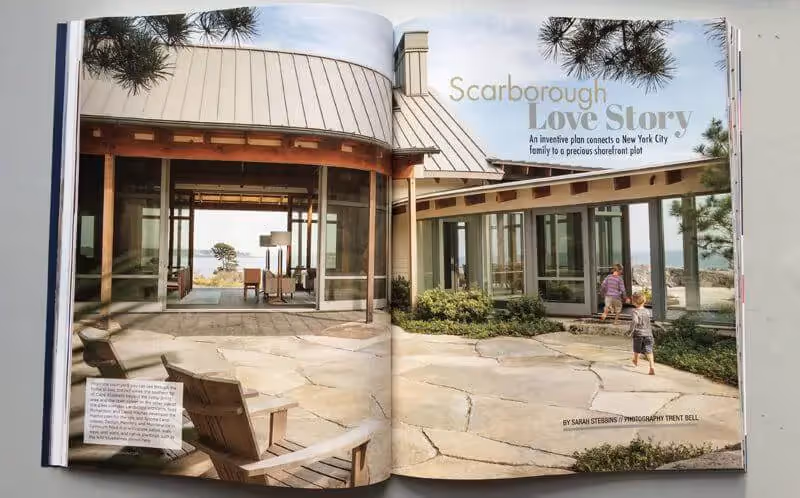 Modern glass house with stone patio and pine trees in Scarborough