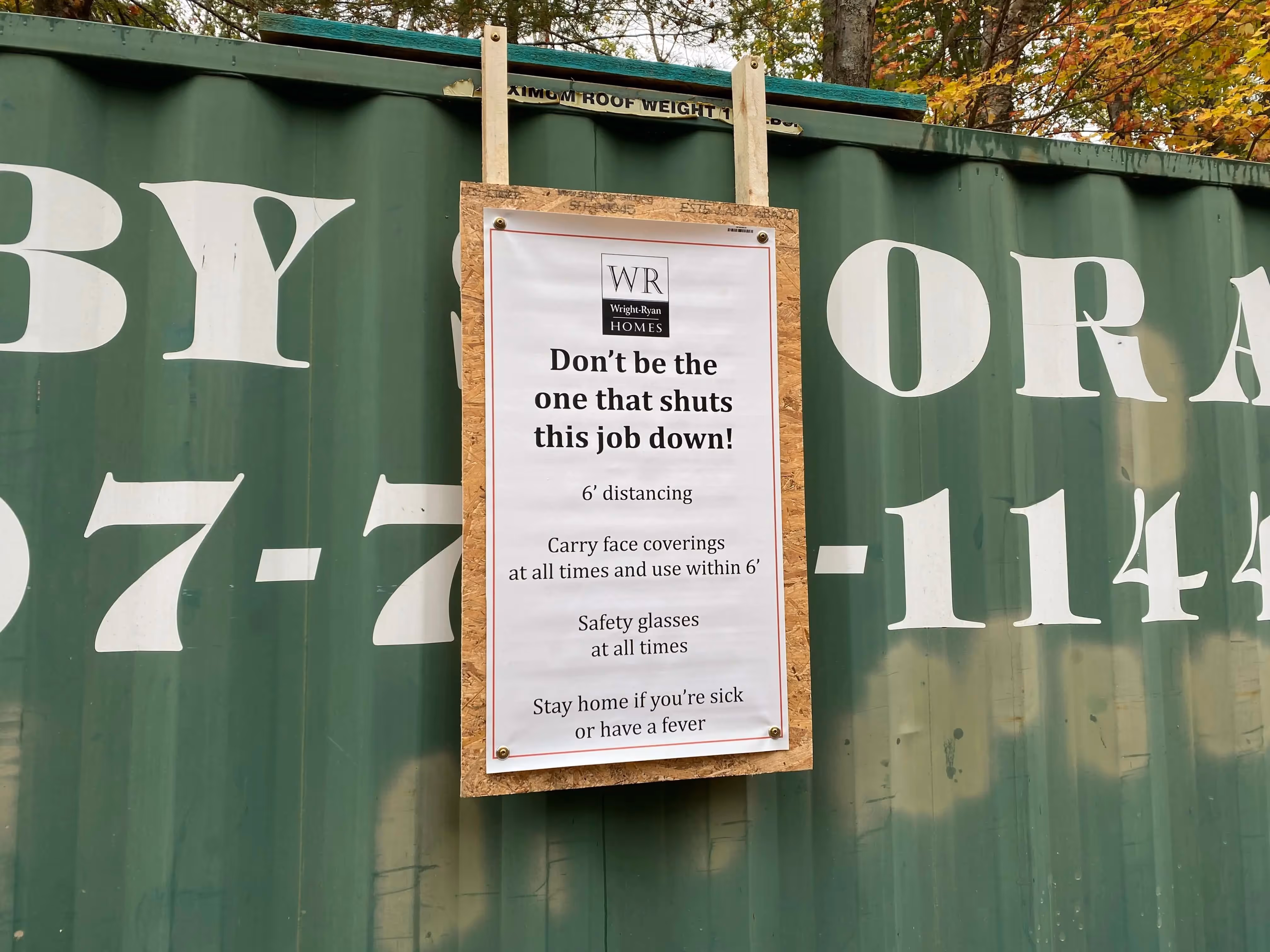 Covid-19 safety poster on green construction site container with guidelines