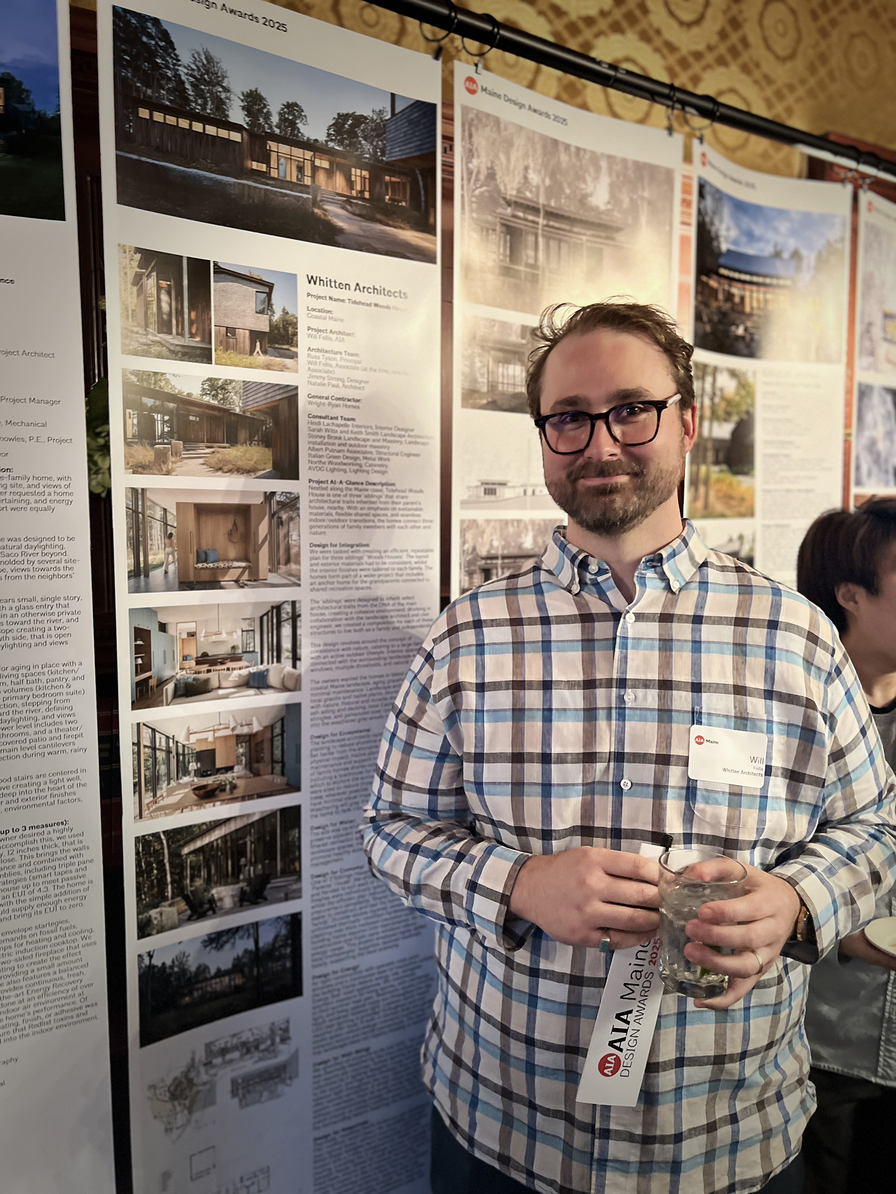 Architect standing next to project poster displaying modern home design sketches