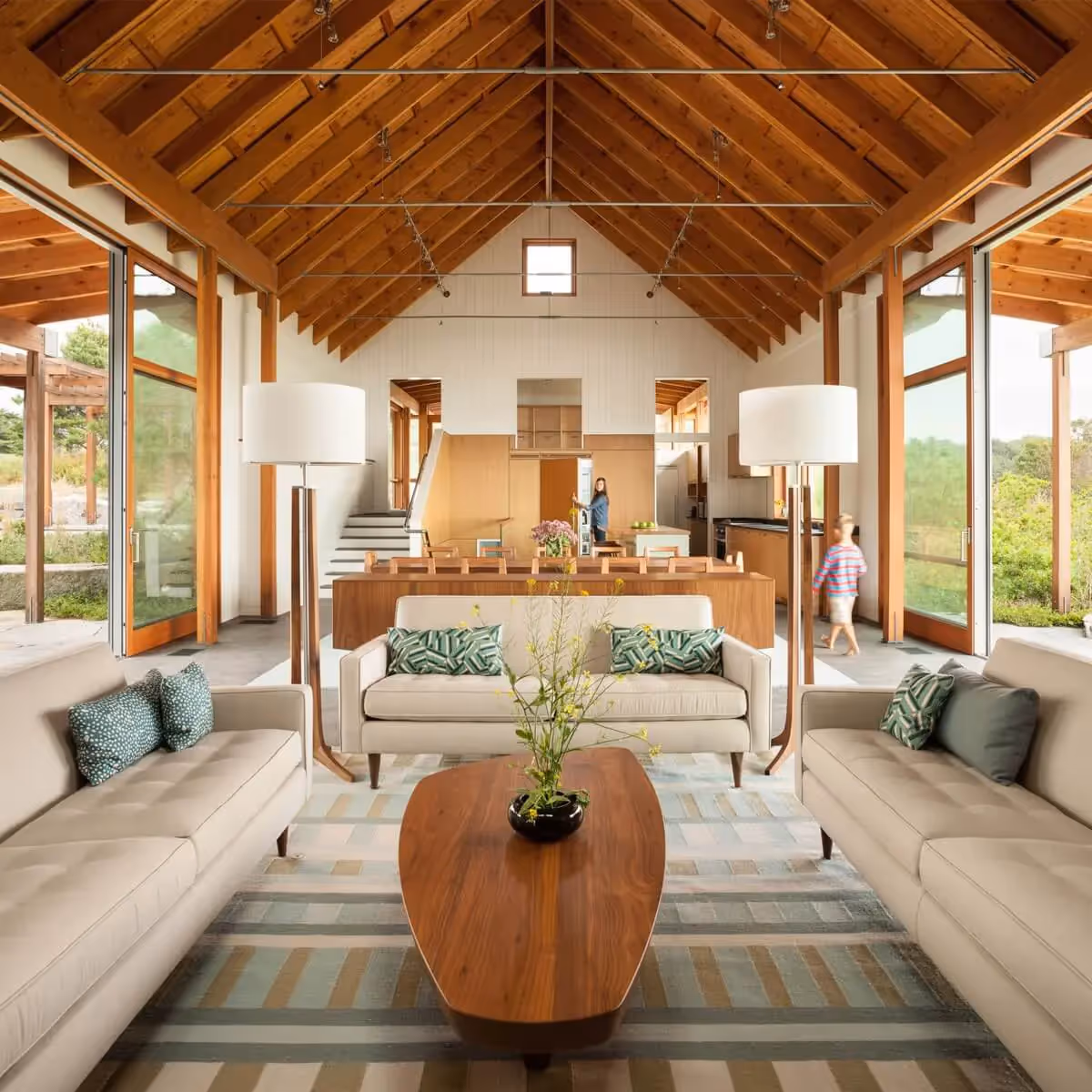 Modern open-plan living space with wood beams and large glass windows