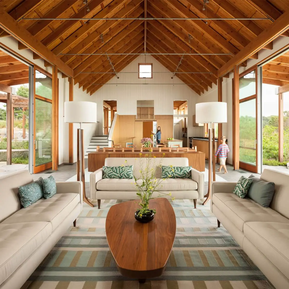 Modern open-plan living space with wood beams and large glass windows