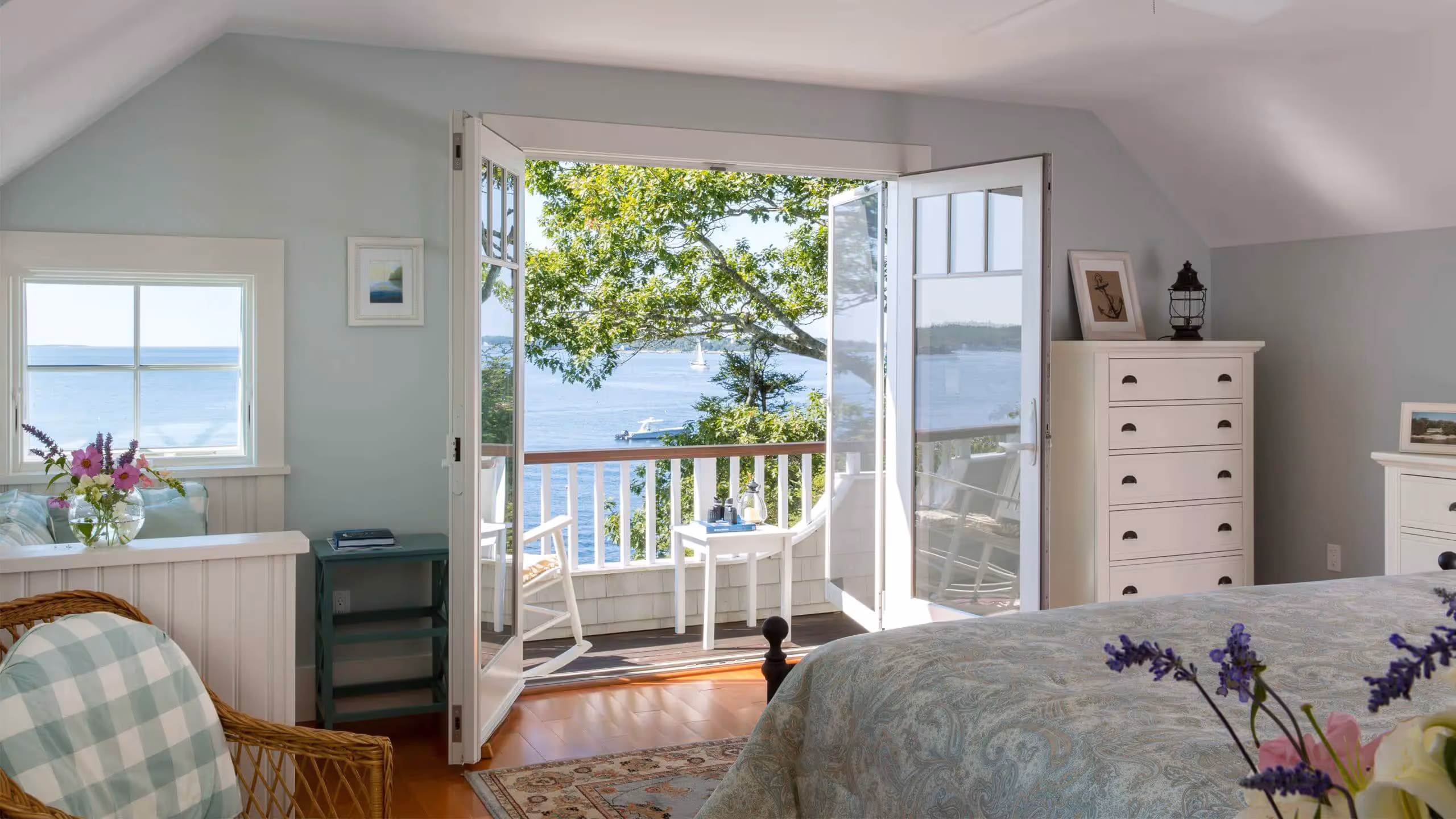 Cozy bedroom with open doors revealing ocean view and balcony