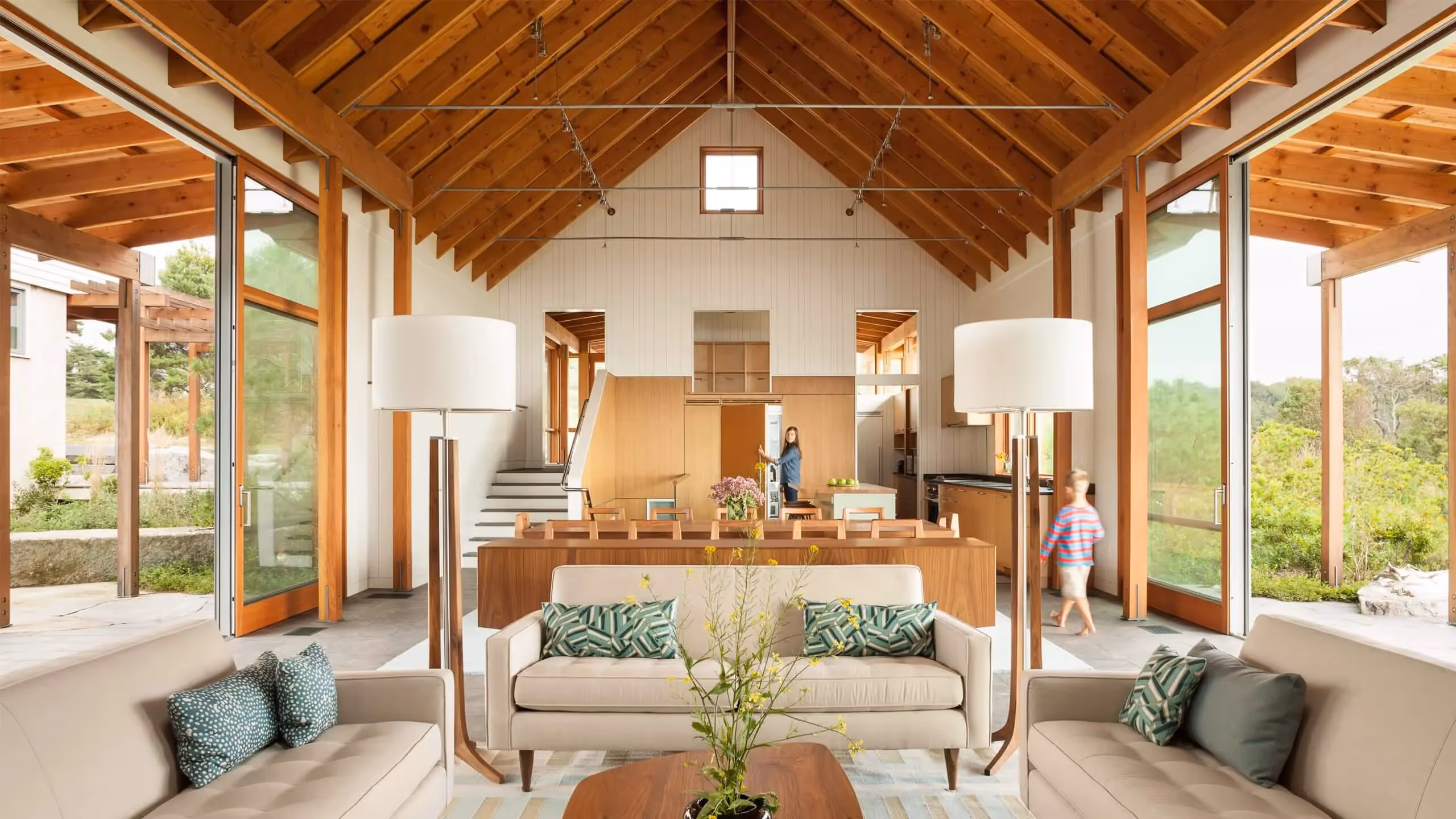 Modern wooden-beamed open-plan interior with large windows and minimalist design