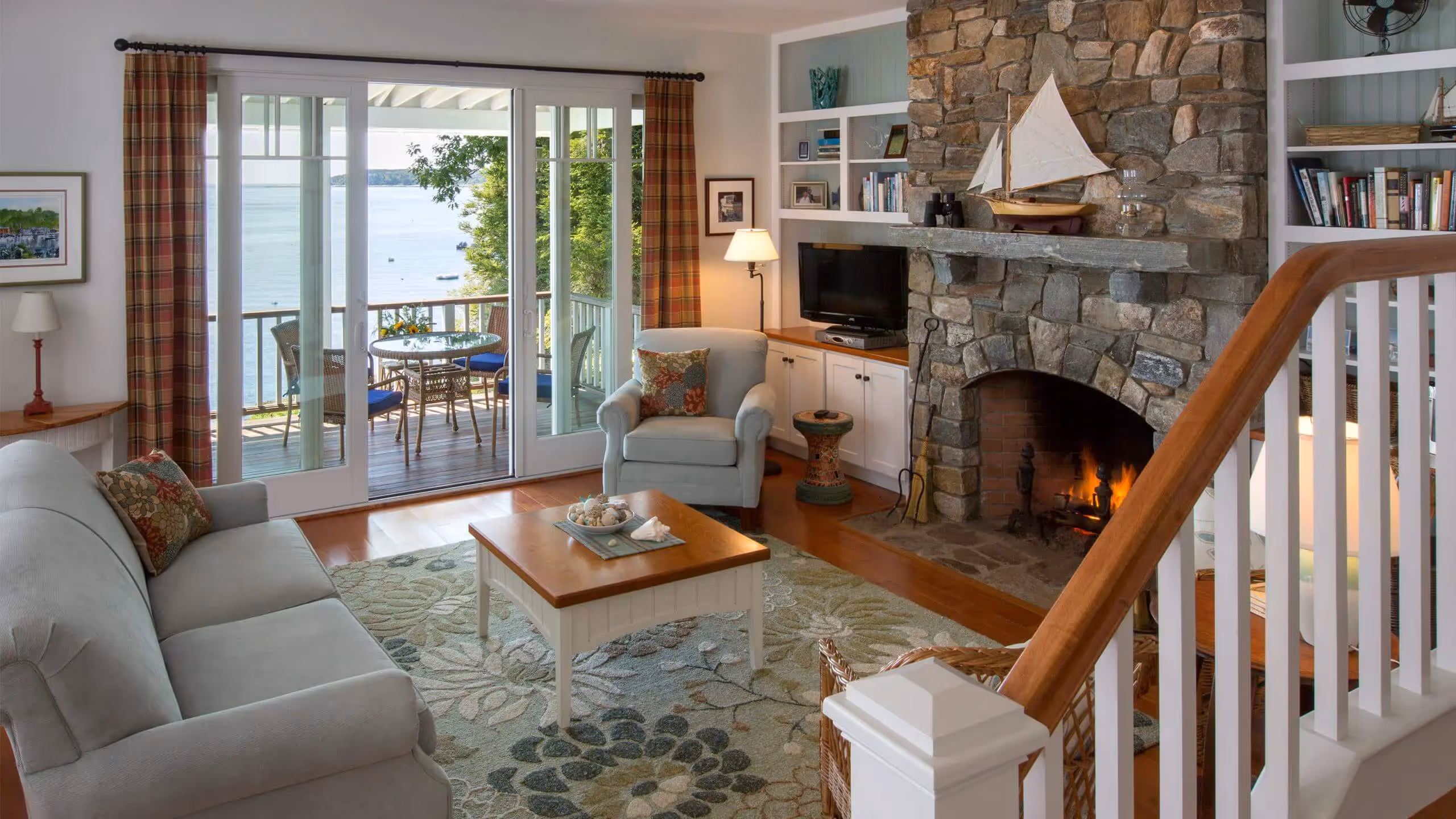 Cozy coastal living room with stone fireplace and ocean view