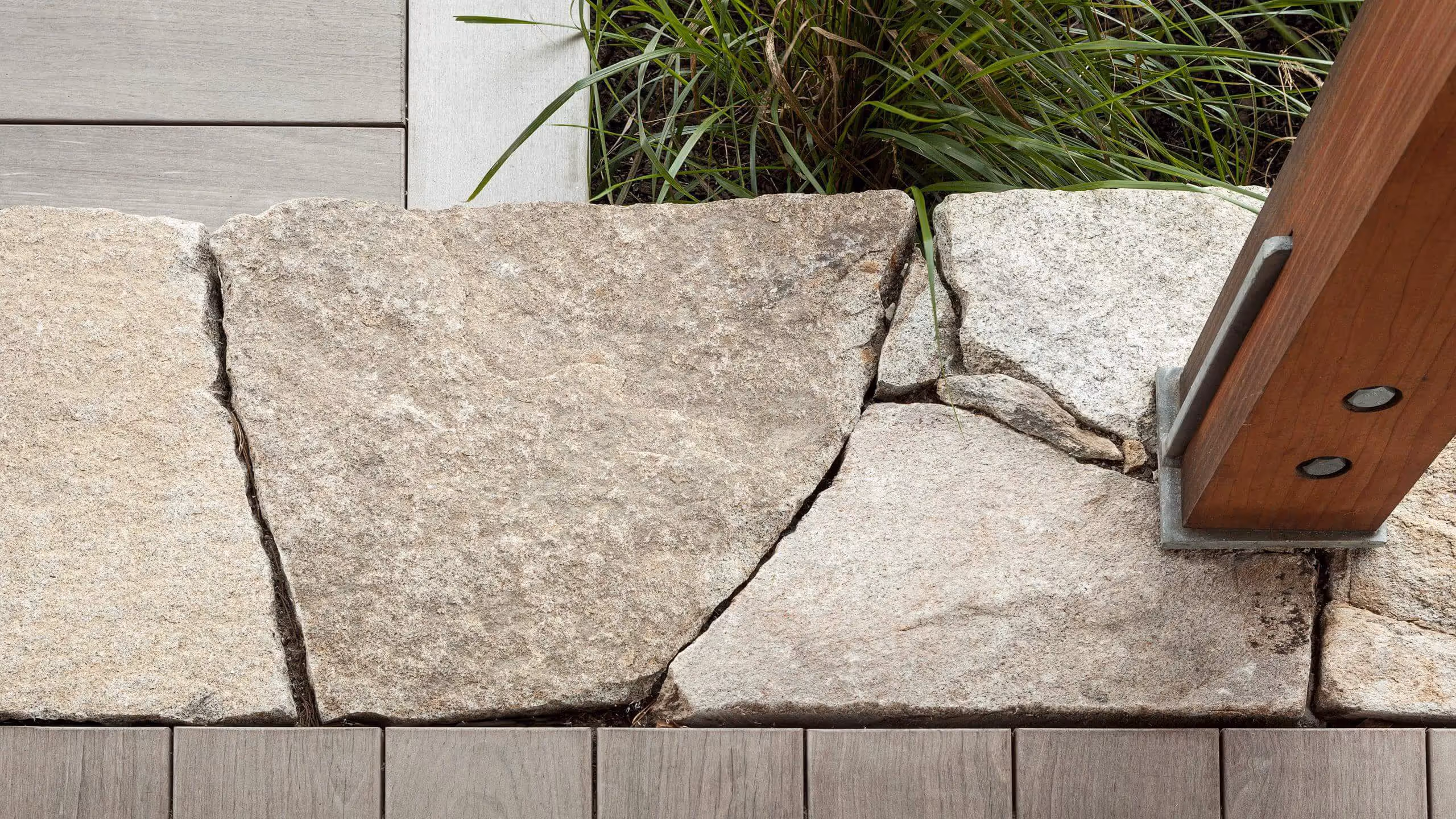 Cracked stone pavers with wooden trim and grass, architectural detail