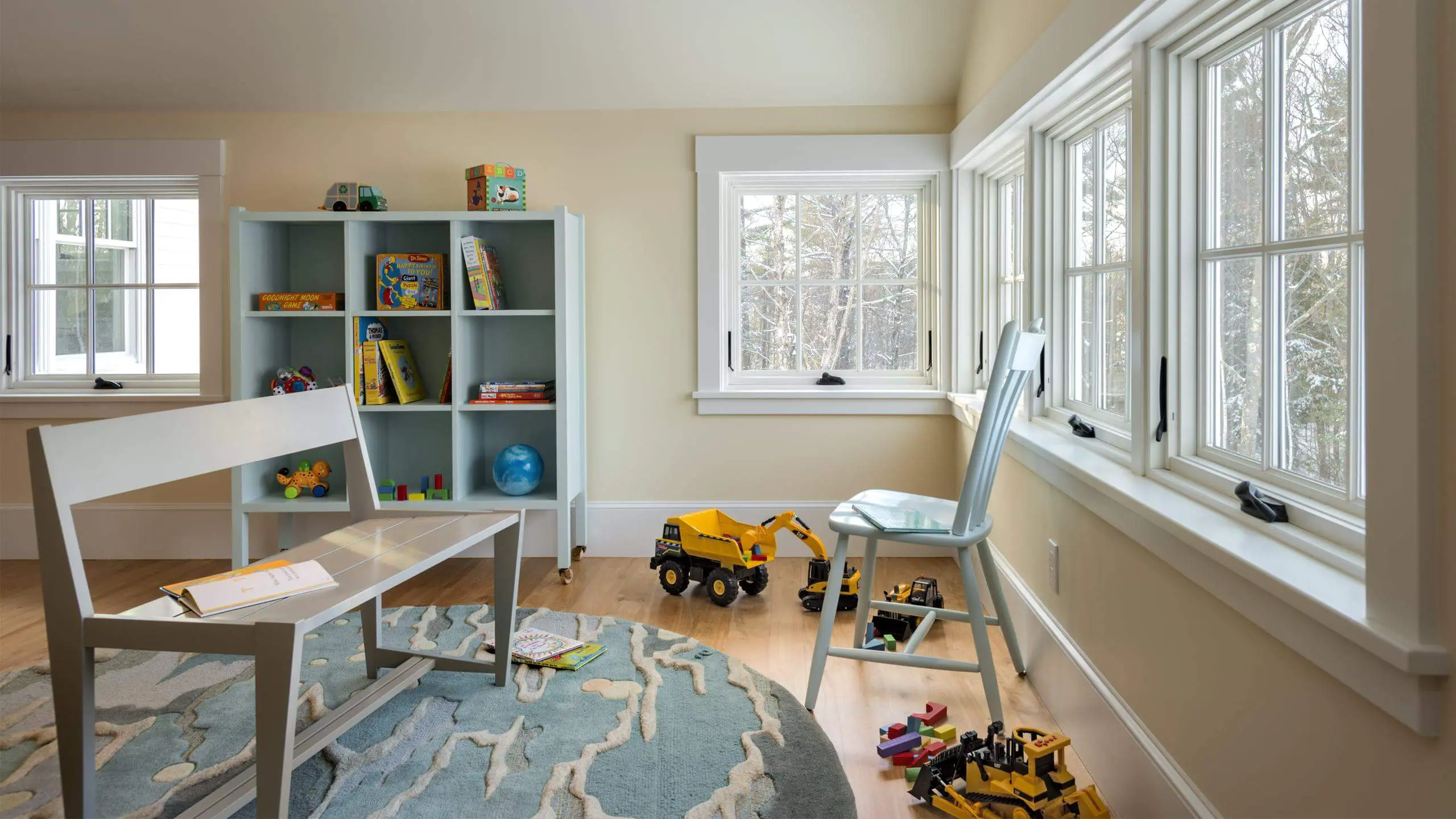 Bright children's room with bookshelf, toys, and construction vehicles