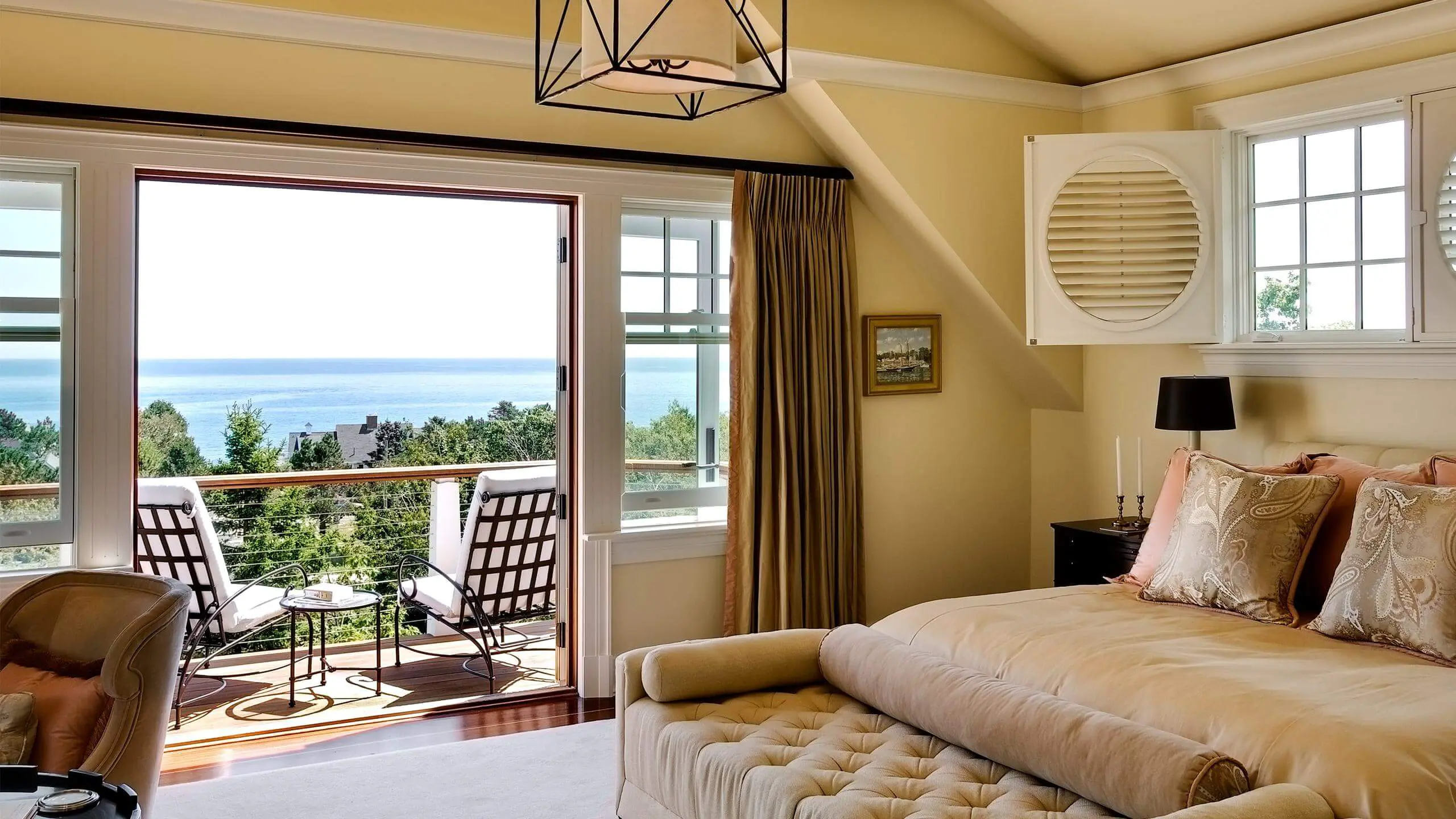 Cozy bedroom with ocean view, balcony, and elegant coastal decor