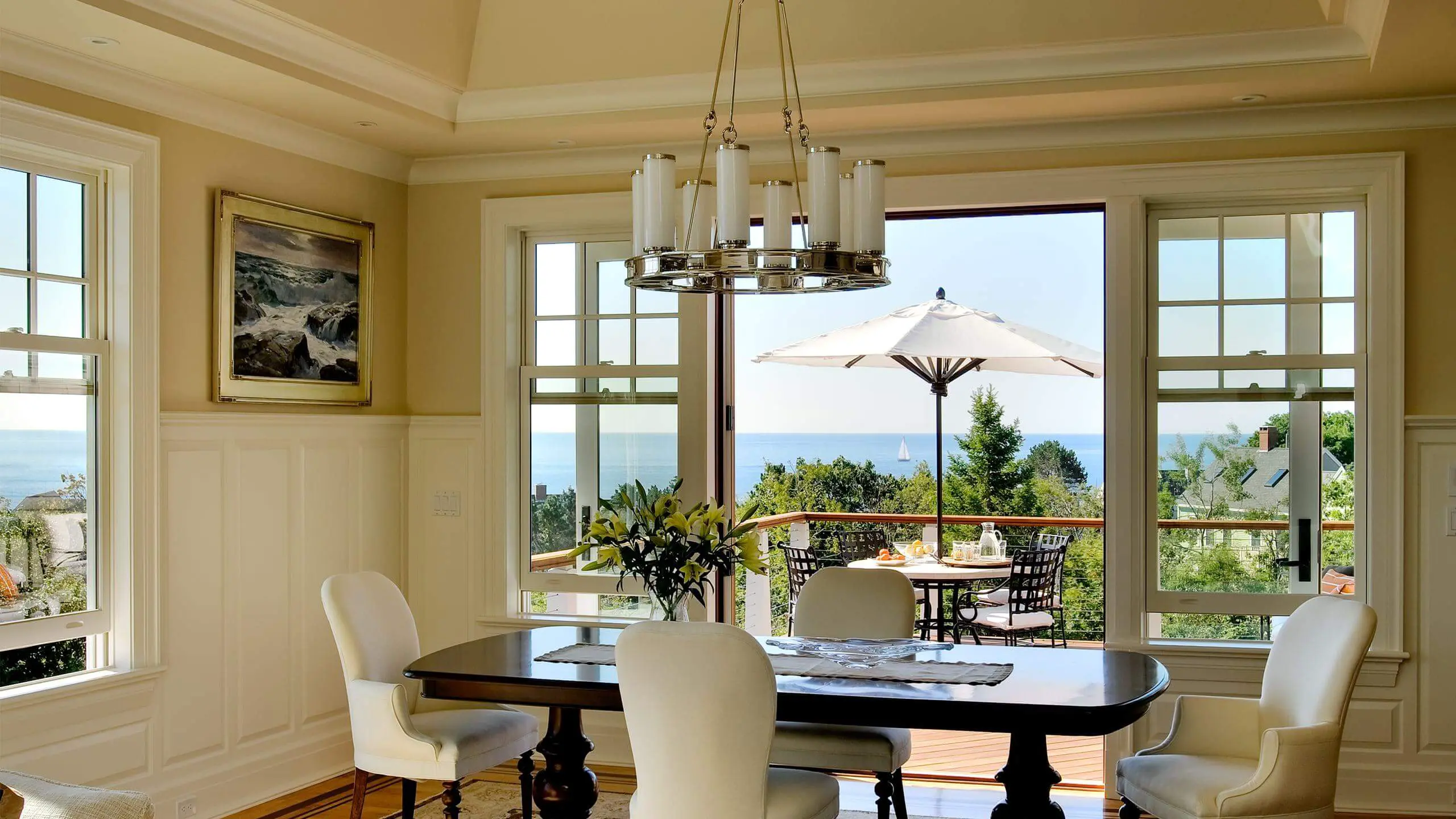 Elegant dining room with ocean view and white umbrella on balcony
