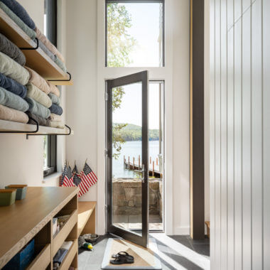 Open door reveals lake view with towels and American flags