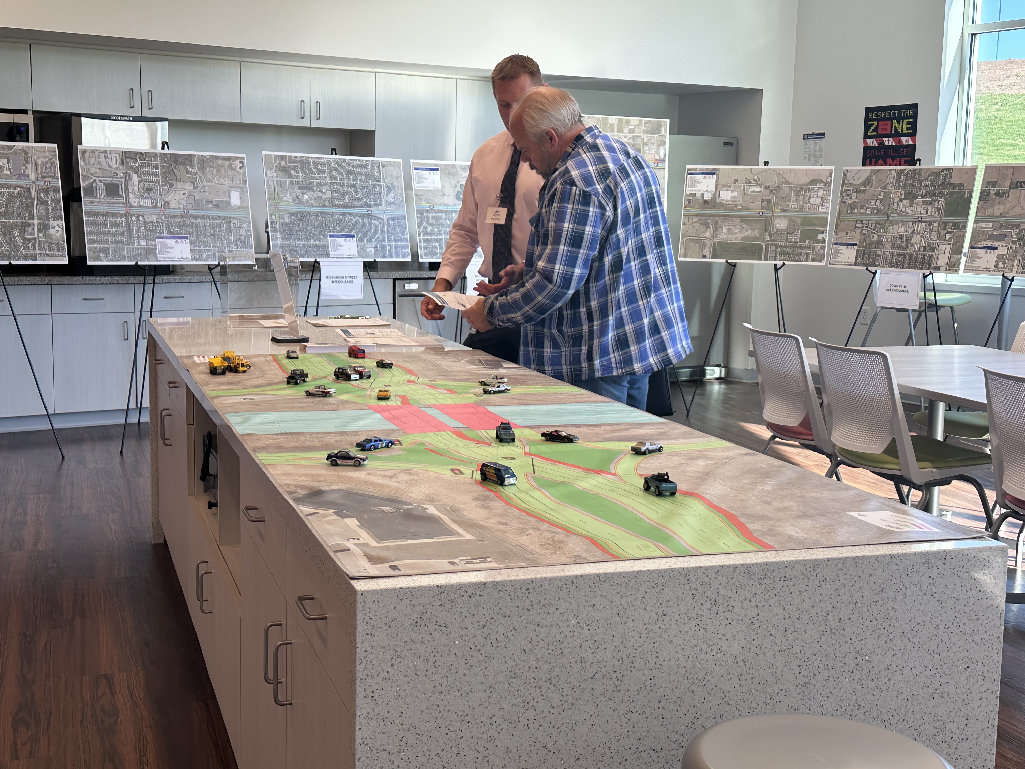 Photo of a stakeholder looking at the 200 scale with a project team member.