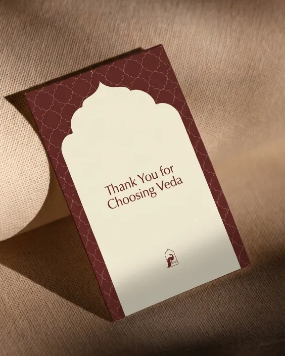 Thank you card on textured fabric reading 'Thank You for Choosing Veda' in brown and cream design.