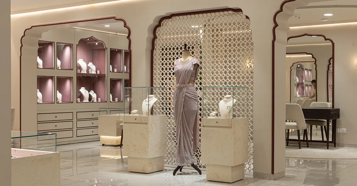 Elegant jewelry store interior with a mannequin in a lavender dress and glass display cases with necklaces.