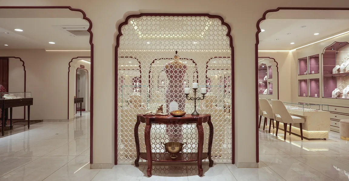 Elegant jewelry store interior with decorative lattice wall, display cases, and seating area.