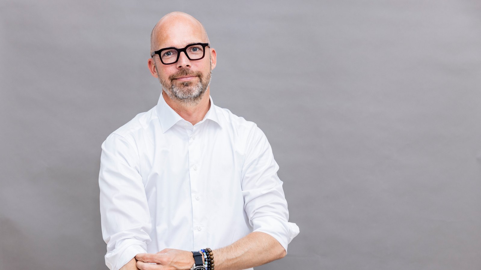 Peter Sorgenfrei, arms folded, in a white shirt