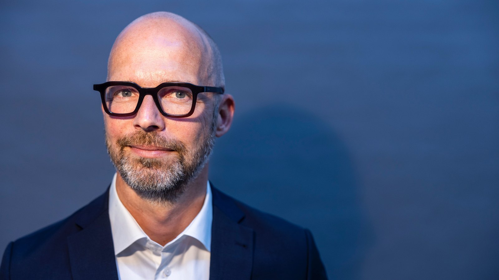 Portrait of Peter Sorgenfrei, CEO coach, against a blue background
