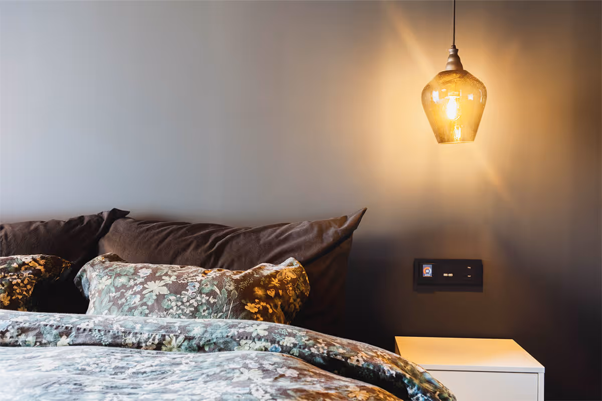 Bildet viser en taklampe ved sengen i et soverom