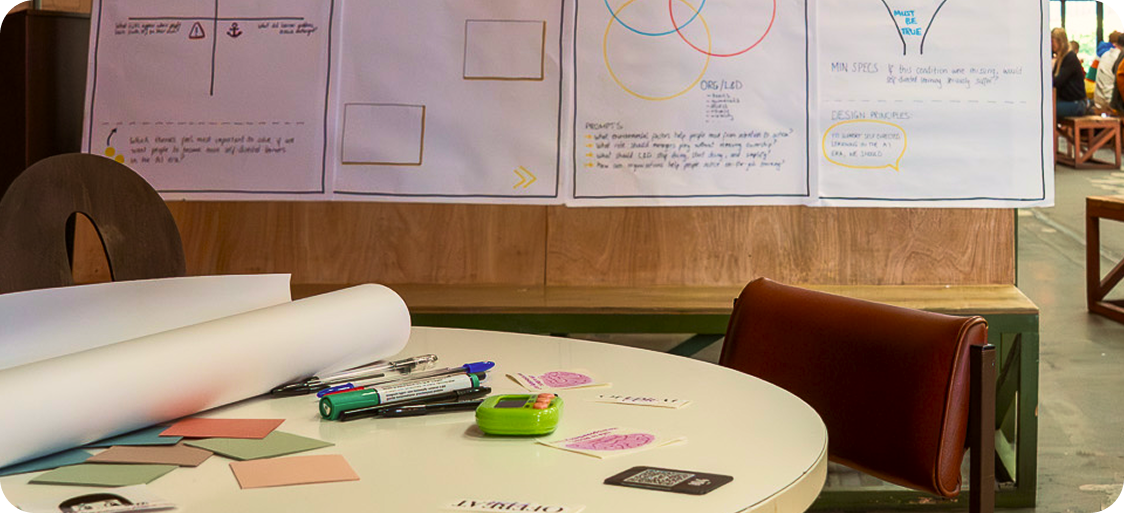Workshop table with markers, sticky notes and flipcharts from an Offbeat session