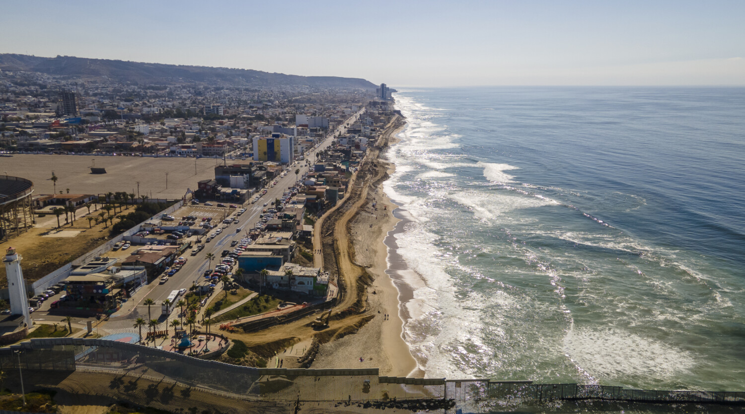 A view of Tijuana along the ocean over the border wall