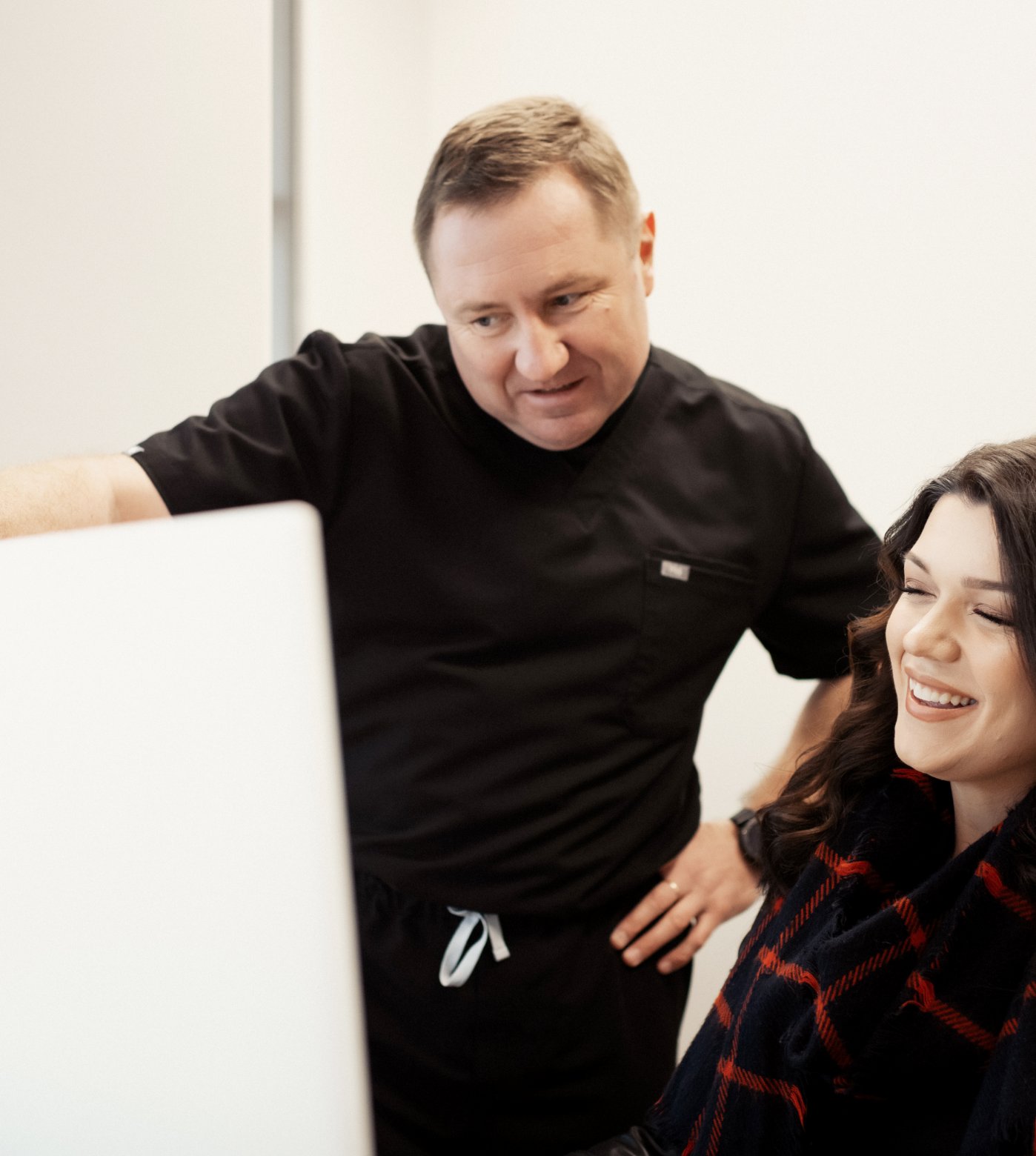 Dr VLADIMIR MELNIKOV and front desk receptionist looking at a monitor