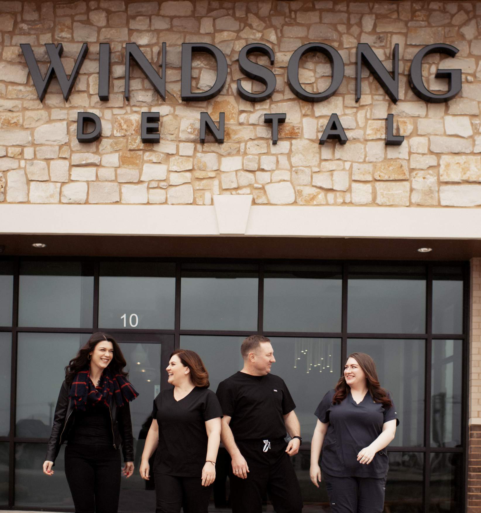 Windsong Dental Team smiling outside the front office 