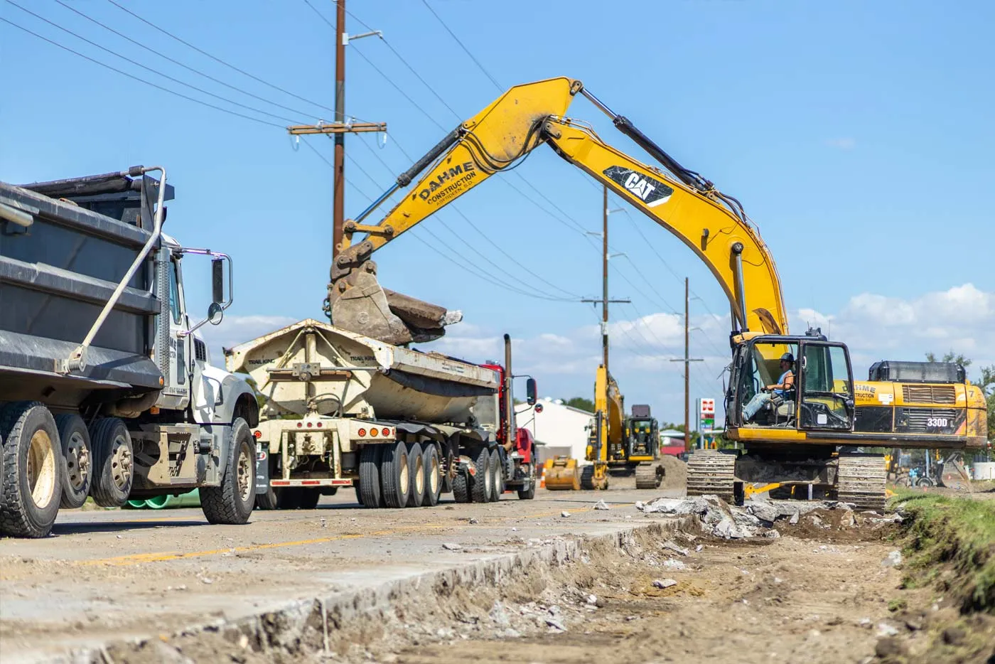 excavator loading debris into truck