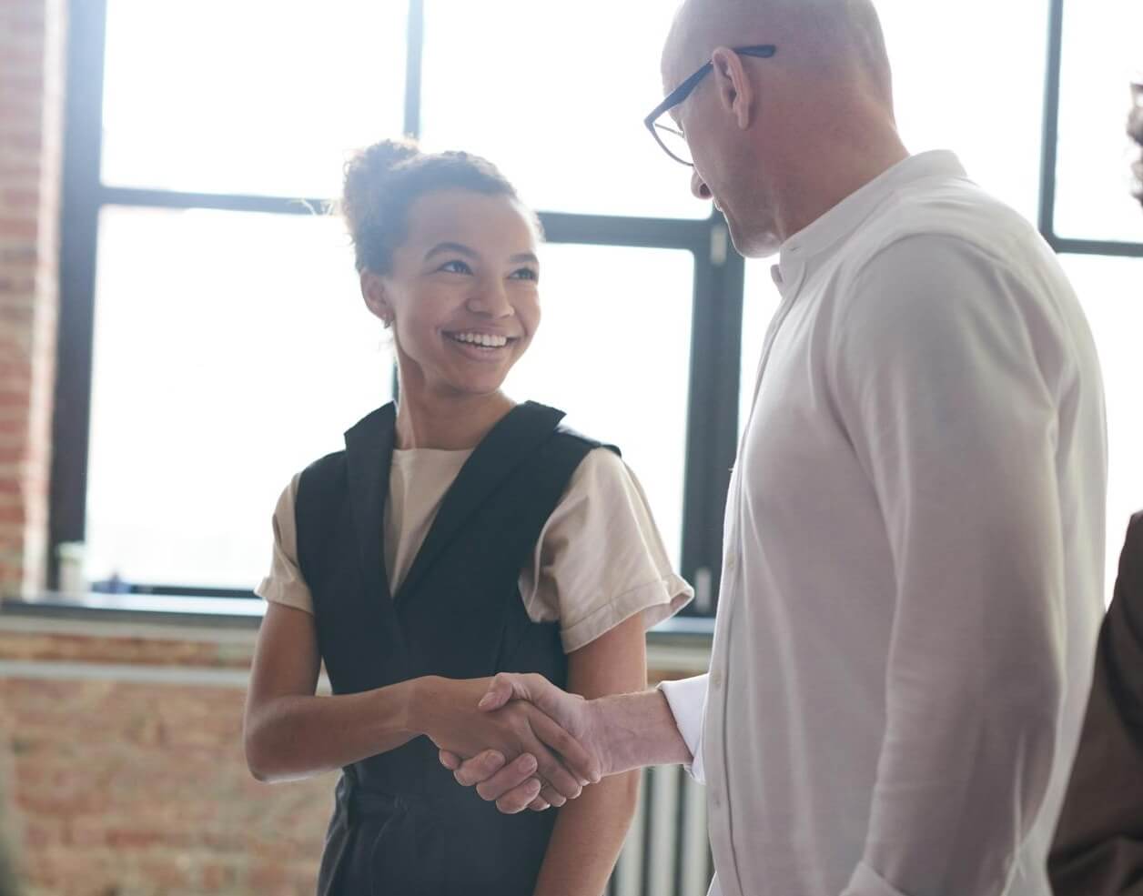 Manager and employee shaking hands after a promotion