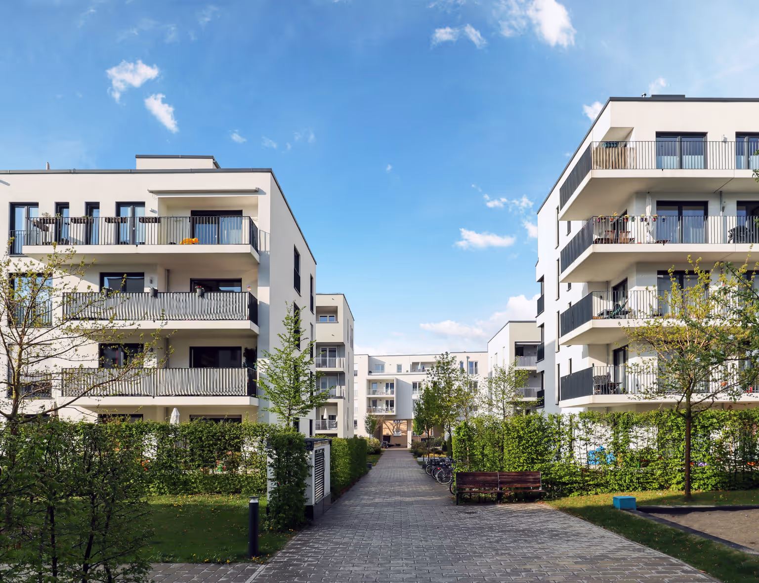 Mehrfamilienhaus verkaufen Bielefeld: Moderne Wohnanlage mit mehreren Mehrfamilienhäusern, Balkonen und gepflegten Grünflächen in ruhiger Lage.
