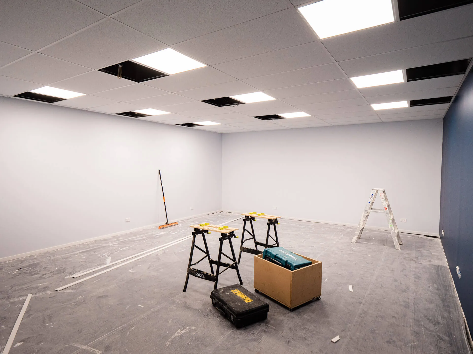 An empty office with new LED ceiling panels and trestles on the floor
