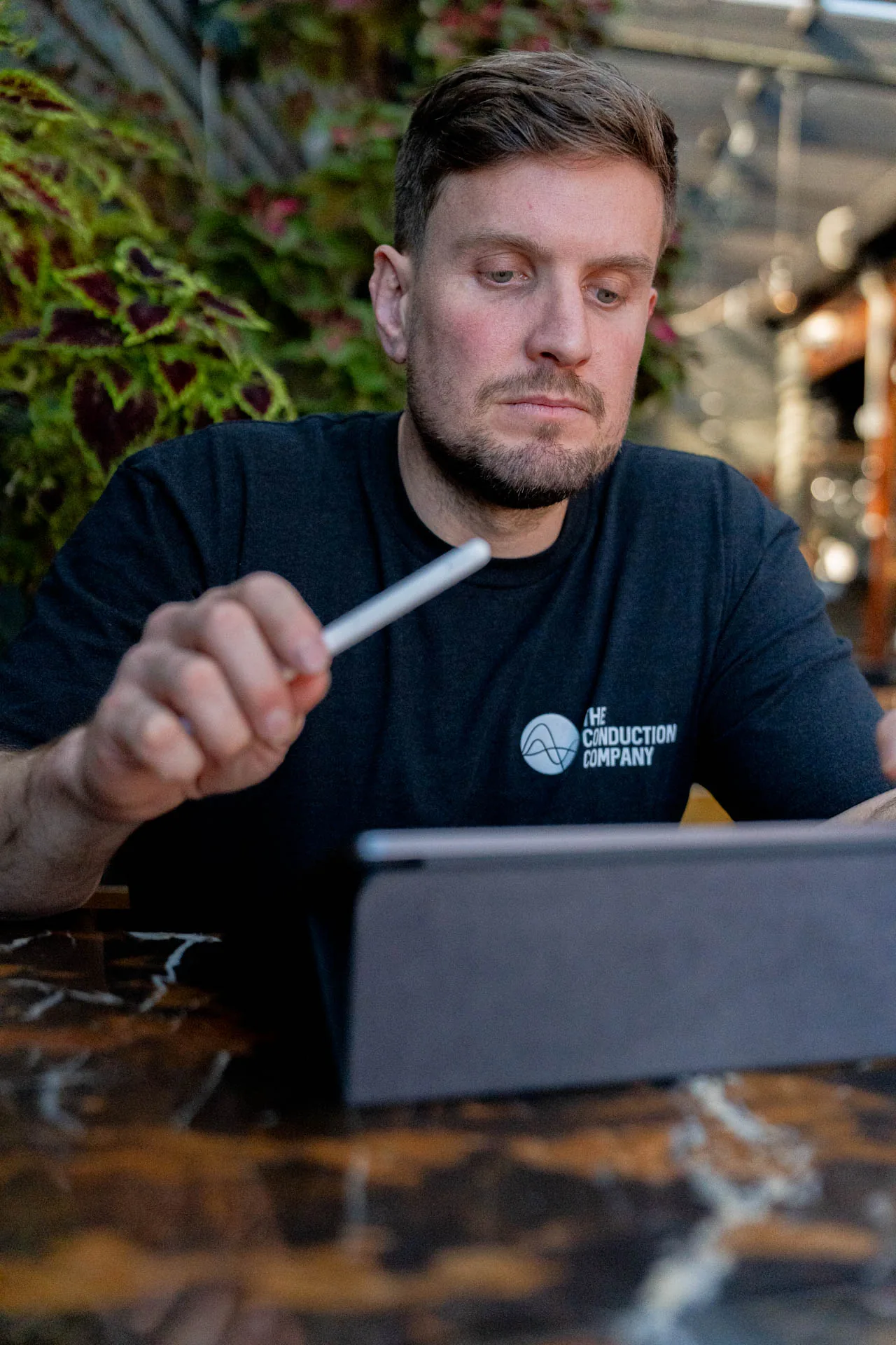 Jordan Statham writing on a tablet at a table