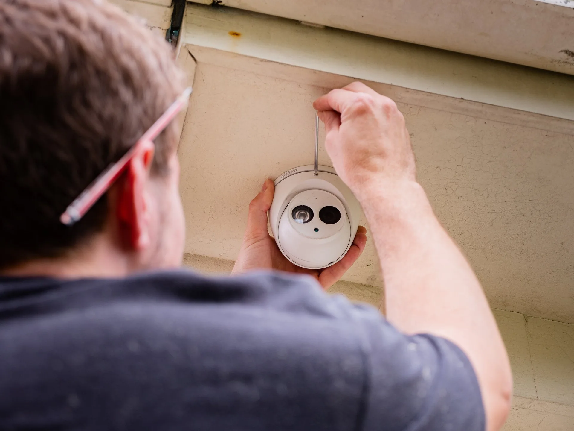 An electrician fitting a smoke alarm to a ceiling