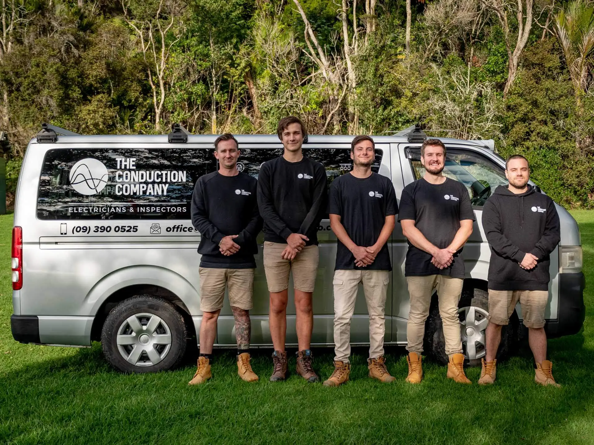 Five Conduction Company electricians standing beside their branded van