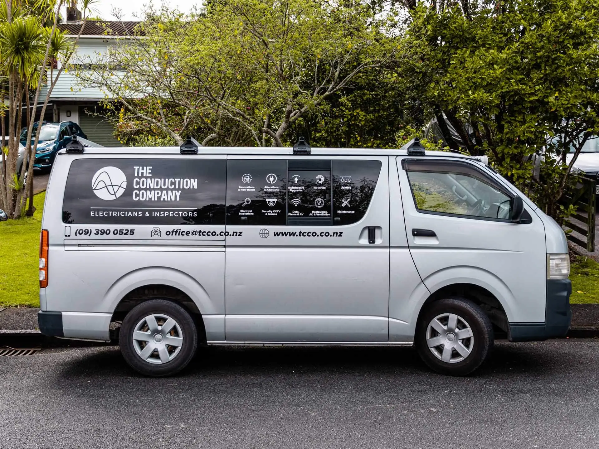 The side of a branded Conduction Company van parked kerbside, its services signwritten along the panel