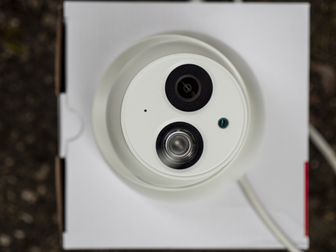A close-up of a white eyeball turret security camera