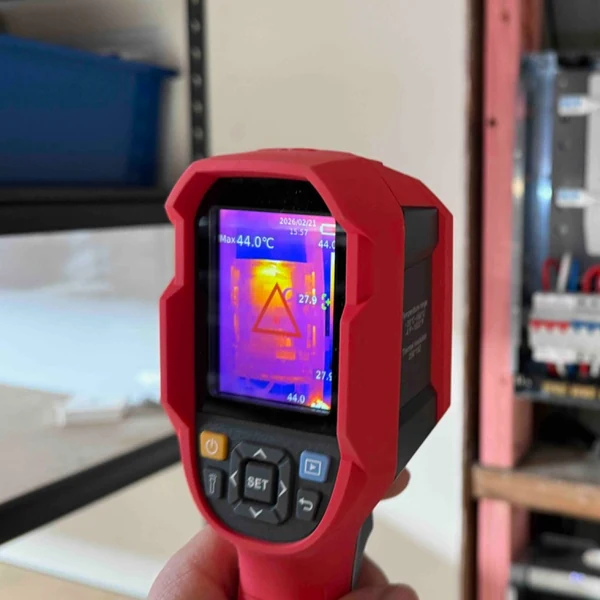 A thermal imaging camera showing a 44 degree hot spot in front of an open switchboard