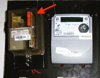 A meter board with a red arrow pointing at the ripple relay beside the electricity meter