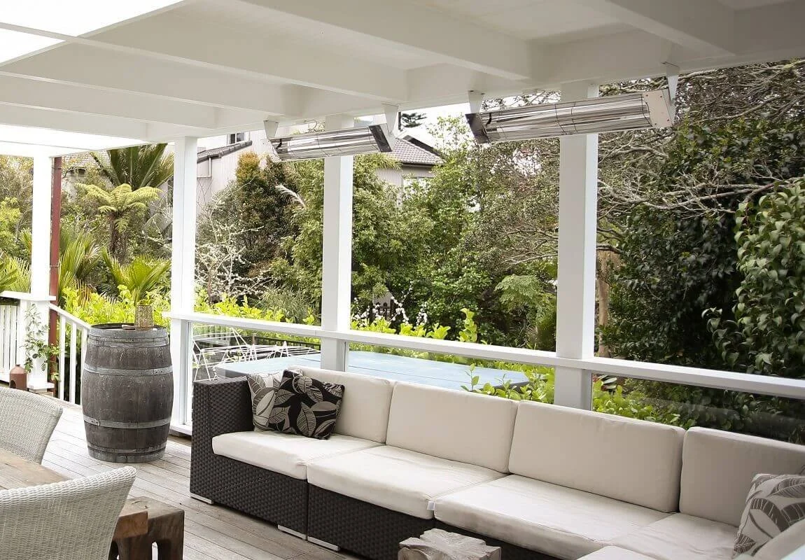 Two stainless infrared heaters under a white pergola above an outdoor lounge