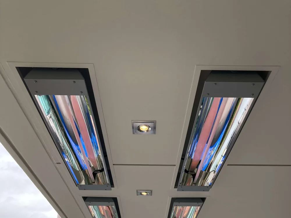 Four infrared heaters recessed side by side into a white soffit ceiling