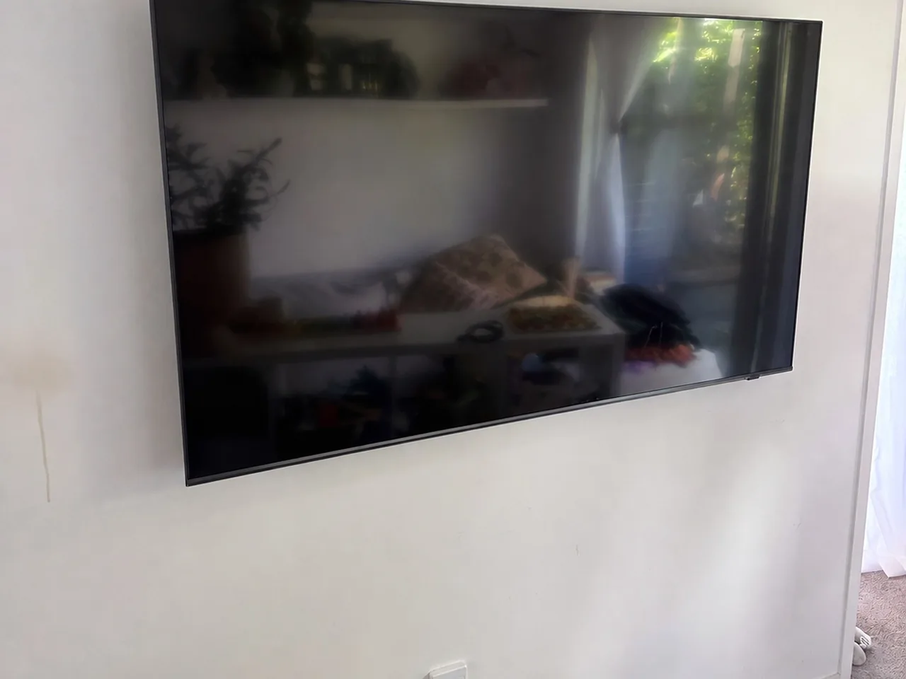 Large television mounted flat on a plain white wall