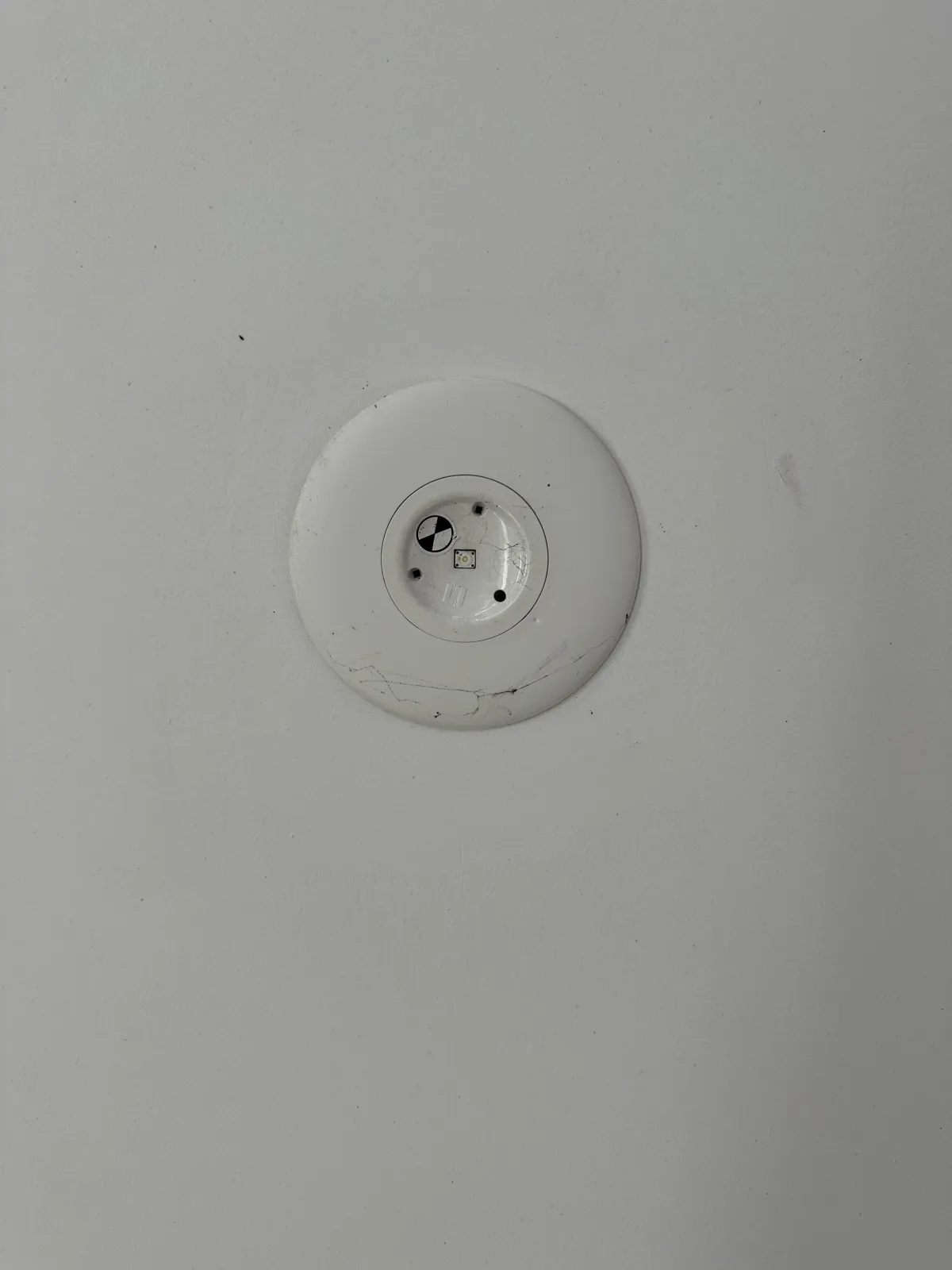 Round emergency light fitting set into a ceiling
