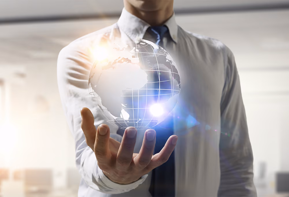 Man in shirt and tie holding a graphic of the world. 