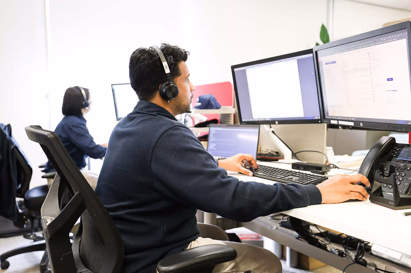 Aerial shot of people working around a desk with computers.