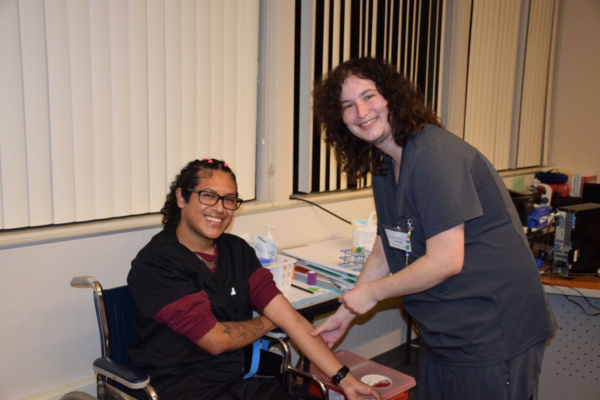 Two healthcare workers smiling together in medical setting